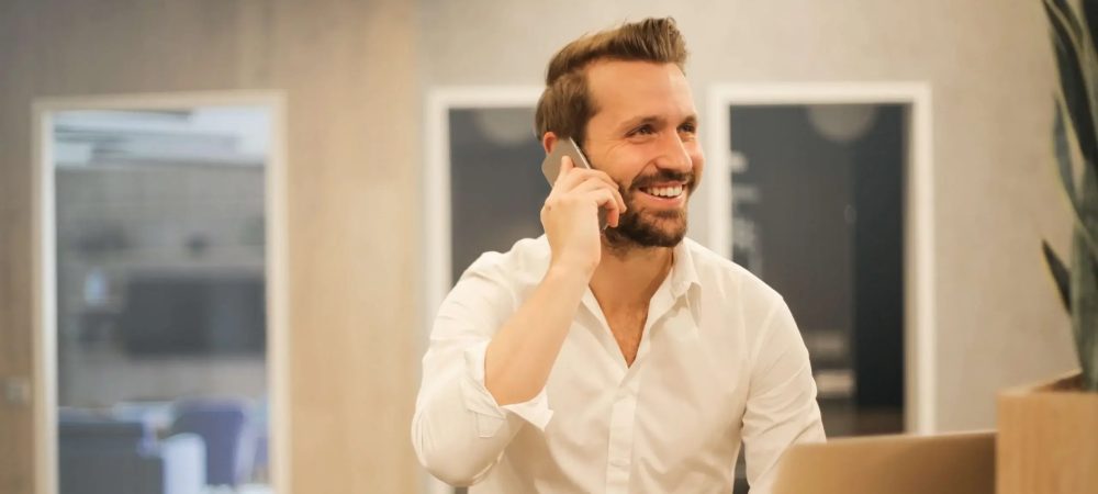 Hipersonolencia 4 Happy man on phone near open laptop