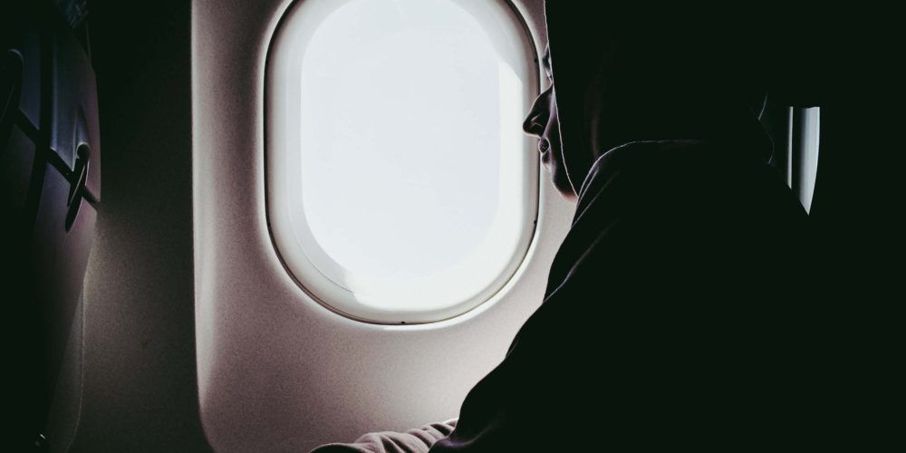 Jet Lag 1 man staring outside a airplane window, jet lagged