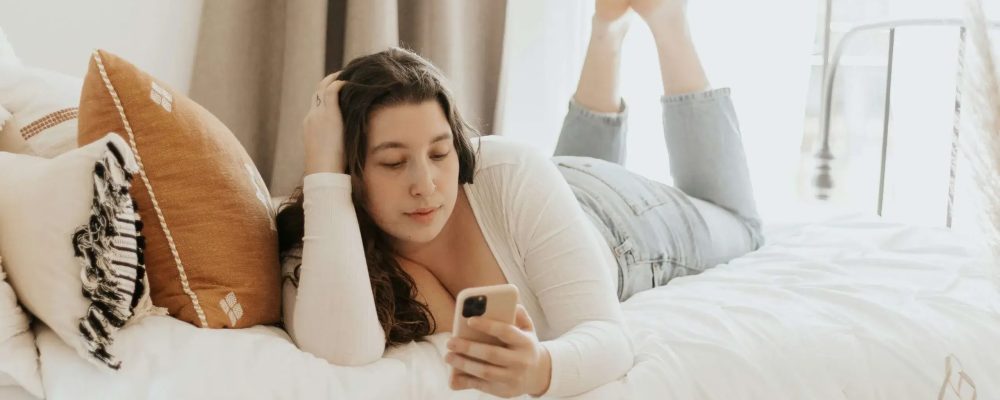 Teenage girl on her phone in bed