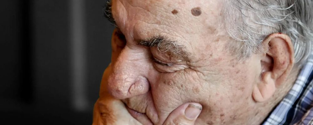 Old man sleeping with his hand on his chin